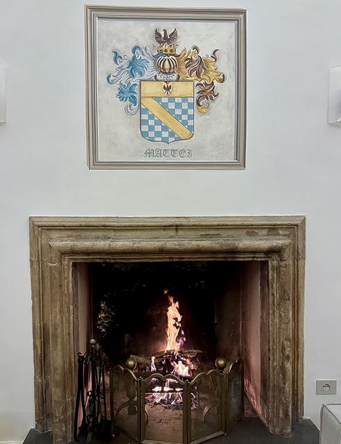 The 17th-century stone fireplace beneath the Mattei crest
